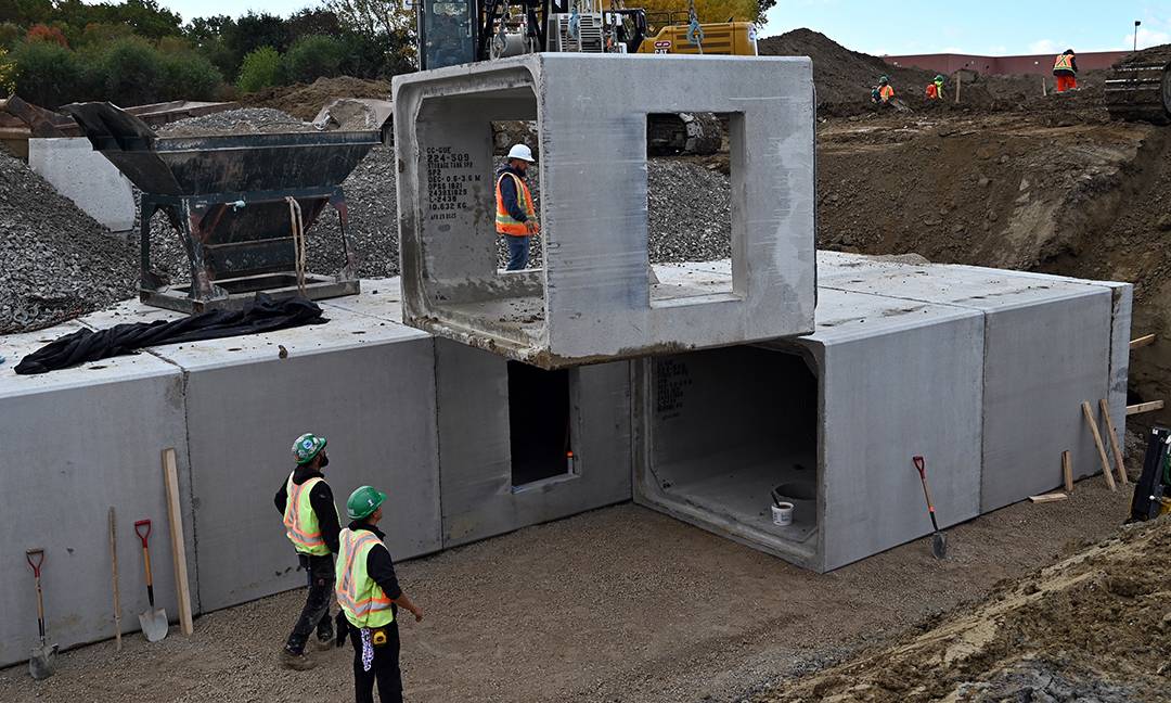box culvert with access points hanging from a crane