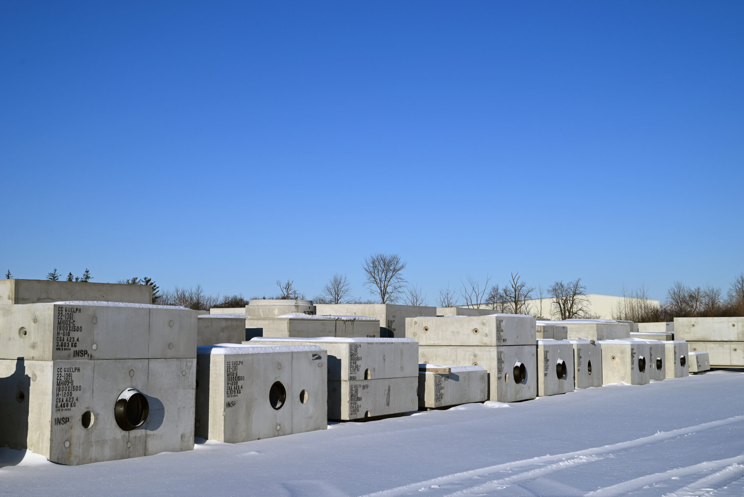 precast concrete products in in the Concast yard covered in snow.