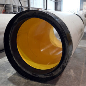A close up shot of a Perfect Pipe with a bright yellow HDPE liner. The pipe is inside the Concast manufacturing plant.