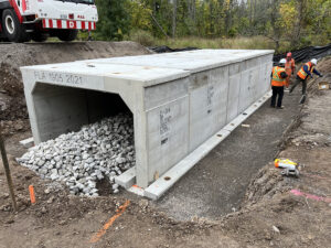 A close up shot of a Tri-Span installation at a job site. three workers measure for accuracy in the background.